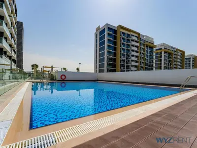 a large swimming pool with buildings in the background at Winter Bliss Studio Azizi Riviera 9 Pool View in Dubai