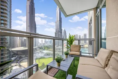 a balcony with a couch and a table at Durrani Homes - Modern Living 3br with Burj Khalifa and Fountain View - third room without partition in Dubai