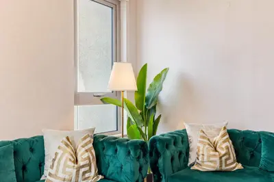 a green couch with pillows in a living room at Durrani Homes - Modern Living 3br with Burj Khalifa and Fountain View - third room without partition in Dubai