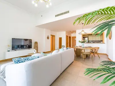 a living room with a white couch and a table at Beachfront Sea View 1BR-Jash Falqa- Palm Jumeirah in Dubai