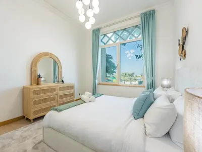 a bedroom with a large white bed and a window at Beachfront Sea View 1BR-Jash Falqa- Palm Jumeirah in Dubai