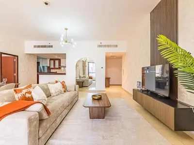 a living room with a couch and a flat screen tv at The Cozy Cove 1BR at Rimal 4,JBR in Dubai