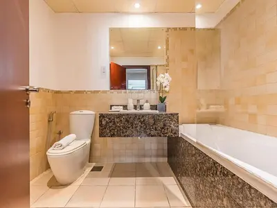 a bathroom with a toilet and a tub and a sink at The Cozy Cove 1BR at Rimal 4,JBR in Dubai