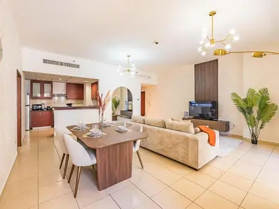 a living room and kitchen with a table and a couch at The Cozy Cove 1BR at Rimal 4,JBR in Dubai