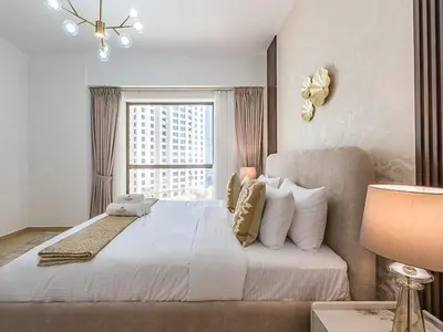 a bedroom with a large white bed with a window at The Cozy Cove 1BR at Rimal 4,JBR in Dubai