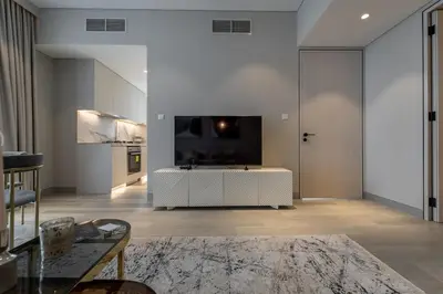 a living room with a white table and a tv at Gracious 1BR in Condor Marina Star, Dubai Marina in Dubai
