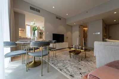 a living room with a table and chairs at Gracious 1BR in Condor Marina Star, Dubai Marina in Dubai