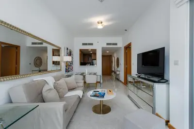 a living room with a couch and a tv at Iris Blue, Dubai Marina - Mint Stay in Dubai