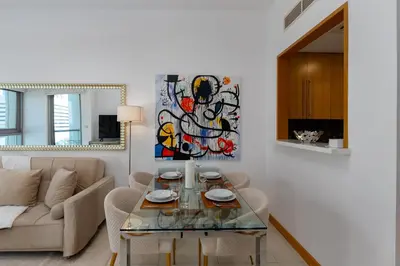 a living room with a glass table and a couch at Iris Blue, Dubai Marina - Mint Stay in Dubai