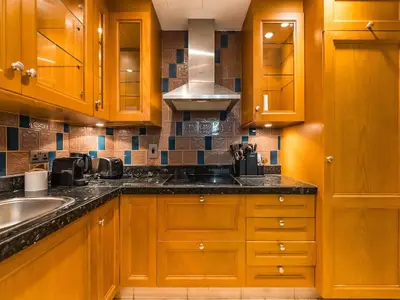a kitchen with wooden cabinets and a sink at Cozy 1BR- Yansoon 4- Heart of Downtown Dubai in Dubai
