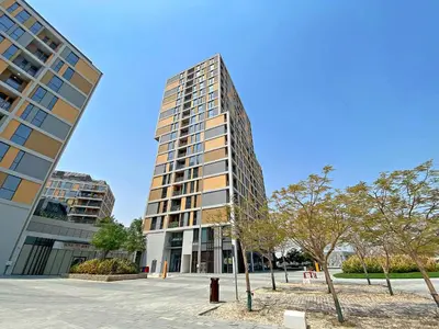 a tall building with trees in front of it at Silkhaus Signature 1BR in Afnan at Production City in Dubai