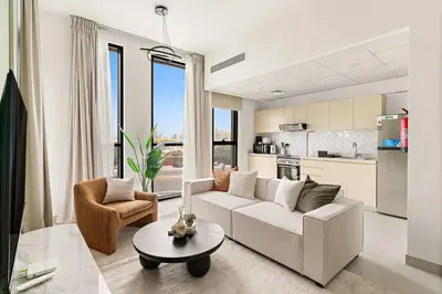 a living room with a white couch and a table at Silkhaus Signature 1BR in Afnan at Production City in Dubai