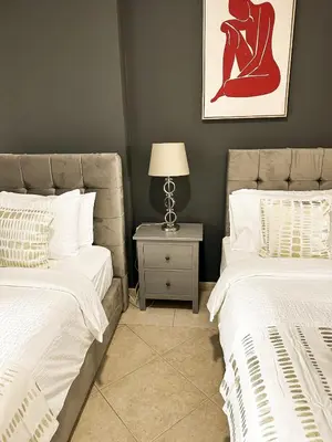 a bedroom with two beds and a table with a lamp at Luxury 2-bedroom in Dubai Marina with Sea View in Dubai