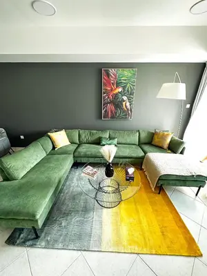 a living room with a green couch and a table at Luxury 2-bedroom in Dubai Marina with Sea View in Dubai