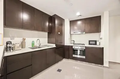 a kitchen with wooden cabinets and a counter top at C&L Homes Dubai Canal in Dubai