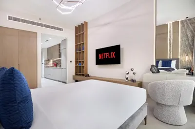 a bedroom with a king sized bed and a chair at Lux High-Rise Studio 12th Floor Westwood Grande in Dubai
