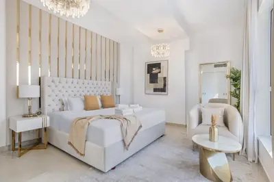 a white bedroom with a white bed and a chair at Classy 2BR Apt in Shams1 Panoramic view in JBR in Dubai