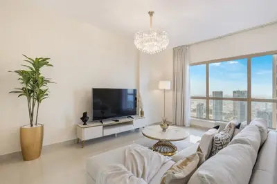 a living room with a white couch and a tv at Classy 2BR Apt in Shams1 Panoramic view in JBR in Dubai