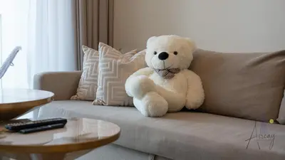 a teddy bear sitting on a couch at Sky-High Downtown 1BR Steps from Burj Khalifa in Dubai