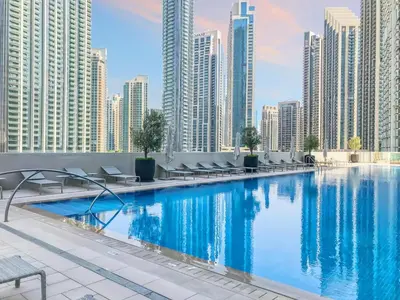 a swimming pool in a city with tall buildings at Sky-High Downtown 1BR Steps from Burj Khalifa in Dubai