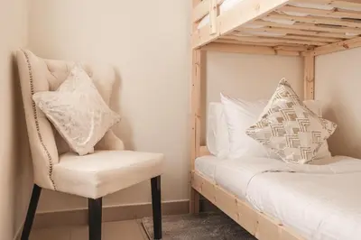 a white chair sitting next to a bunk bed at Elite Royal Apartment - Sky Series - Luxurious in Dubai