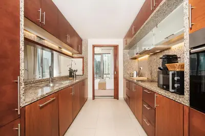 a large kitchen with wooden cabinets and a sink at Elite Royal Apartment - Sky Series - Luxurious in Dubai