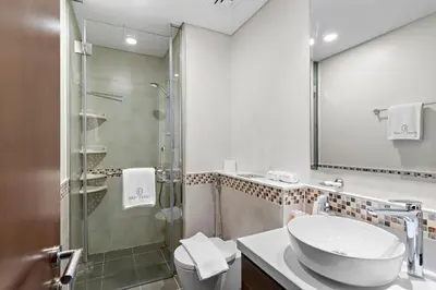 a bathroom with a sink and a shower and a toilet at Sleek 1BR Apt with Pool Gym by Dubai Canal, Dubai Mall & Business Bay in Dubai