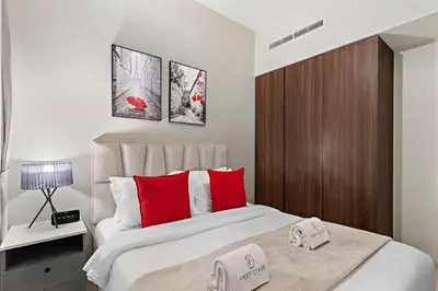 a bedroom with a large bed with red pillows at Sleek 1BR Apt with Pool Gym by Dubai Canal, Dubai Mall & Business Bay in Dubai