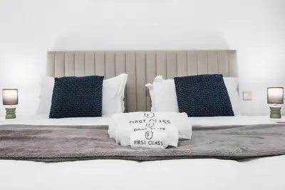 a bed with blue and white pillows on it at Relaxing 1BR in Dubai With Access to Pool, Gym & Parking in Dubai