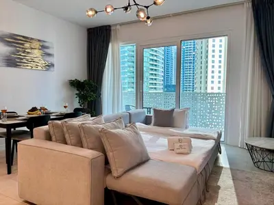 a living room with a couch and a large window at Relaxing 1BR in Dubai With Access to Pool, Gym & Parking in Dubai