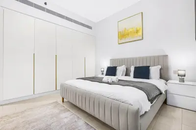 a white bedroom with a large bed in it at Relaxing 1BR in Dubai With Access to Pool, Gym & Parking in Dubai