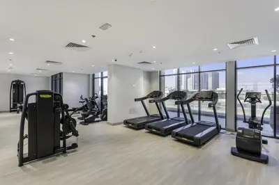 a gym with treadmills and ellipticals in a building at Elegant Cozy Stu Luxury Stay 10 Min Dubai Mall in Dubai