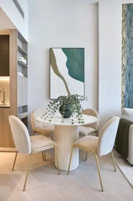 a dining room with a table with chairs and a vase at Chic-1BROxford Terrace 2 Luxuriously Furnished in Dubai