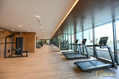 a row of treadmills in a gym with windows at Stunning 1BR in JVC Binghatti Amber by Deleguest in Dubai