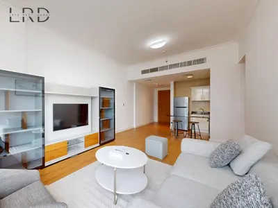 a living room with a white couch and a table at Charming 1BR Apartment with Canal View in Business Bay in Dubai