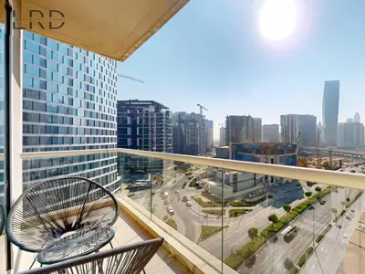 a balcony with two chairs and a view of a city at Charming 1BR Apartment with Canal View in Business Bay in Dubai