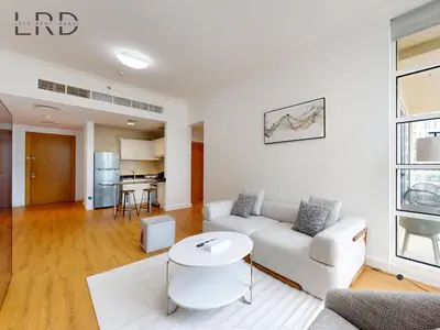 a living room with a white couch and a table at Charming 1BR Apartment with Canal View in Business Bay in Dubai