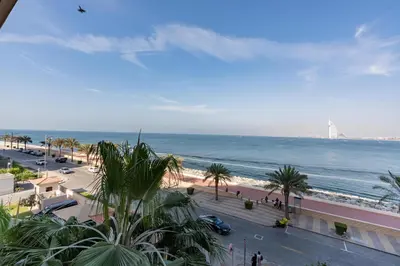 a view of the beach and the ocean from a building at Burj & Sea View King 2 Bedroom Apartment In Anantara Resort in Dubai
