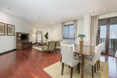 a dining room and living room with a table and chairs at Burj & Sea View King 2 Bedroom Apartment In Anantara Resort in Dubai