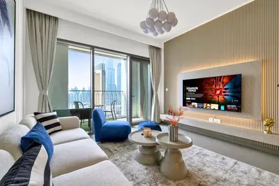 a living room with a white couch and a tv at Vibrant Luxe Burj Khalifa Views-Dubai Mall Access by Maxx Value Homes in Dubai