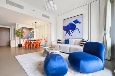 a living room with blue chairs and a couch at Vibrant Luxe Burj Khalifa Views-Dubai Mall Access by Maxx Value Homes in Dubai