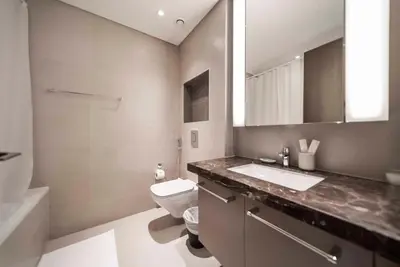 a bathroom with a toilet and a sink and a mirror at Downtown Dubai Luxury 1 BR in BLVD Heights T1 in Dubai