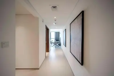a hallway with white walls and paintings on the walls at Downtown Dubai Luxury 1 BR in BLVD Heights T1 in Dubai