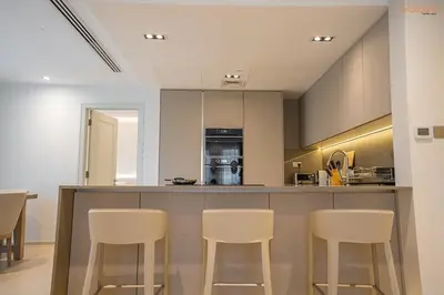a kitchen with a bar with stools at Bnbeyond's Luxury Vibe & Burj View in Dubai
