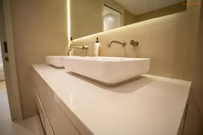 a white bathroom with two sinks and a mirror at Bnbeyond's Luxury Vibe & Burj View in Dubai