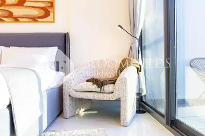 a cat sleeping in a chair next to a bed at Bloomfields Charming Stu in Samana View in Dubai
