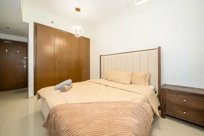 a bedroom with a large bed and a wooden cabinet at Lavish 1 bedroom in Dubai