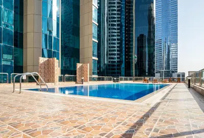 a swimming pool in a city with tall buildings at Lavish 1 bedroom in Dubai
