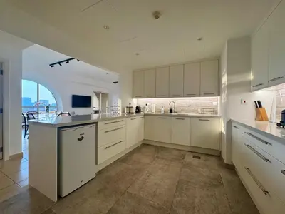 a large kitchen with white cabinets and a large window at Large 5-BR JBR Apartment, Perfect for Families, Easy Beach Access in Dubai