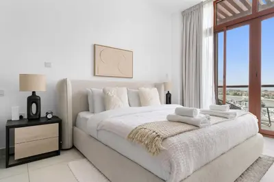 a white bedroom with a large bed and a window at Silkhaus Seaside Studio in Palm Views West Tower in Dubai